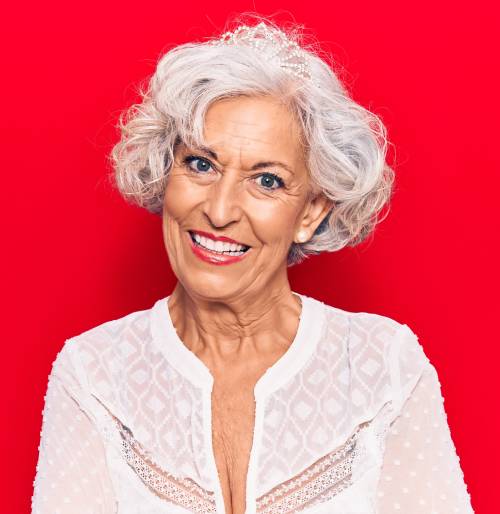 Gray curly bob with side swept bangs hairstyle for women over 50