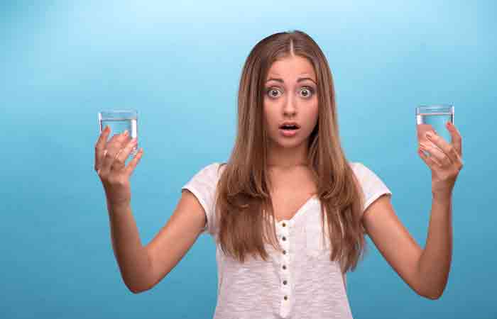 Woman holding glasses of hot and cold water