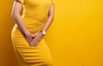 Woman experiencing vaginal infection presses her hands to her crotch