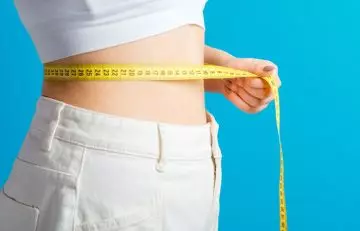 A woman measuring her waist size