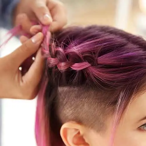 A woman getting her ombre hair styled in a braid