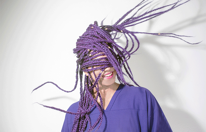 A young woman with purple box braids