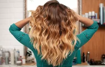 Back view of woman with golden ombre hair color on flicked out ends