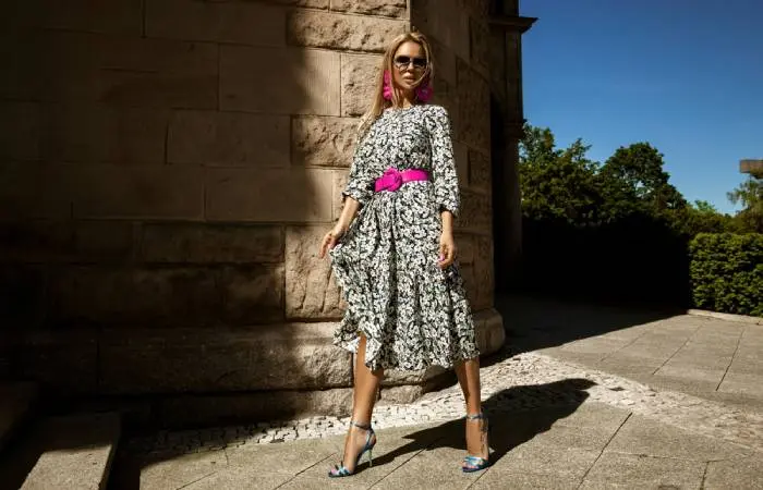 A woman in a midi floral dress and strappy heels