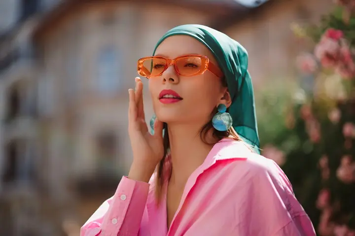 Woman wearing bold earrings and a headscarf