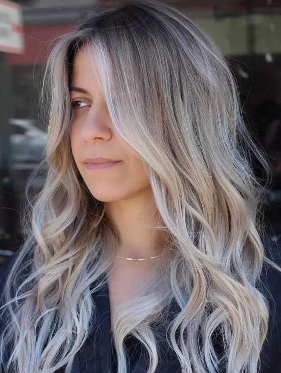 Ash blonde root melt with dark grey roots at the top and a bright ash blonde hair color towards the ends