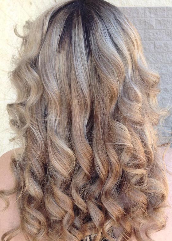 Mid-lengths colored in an ash blonde hair color with natural dark roots left for shadow root effect