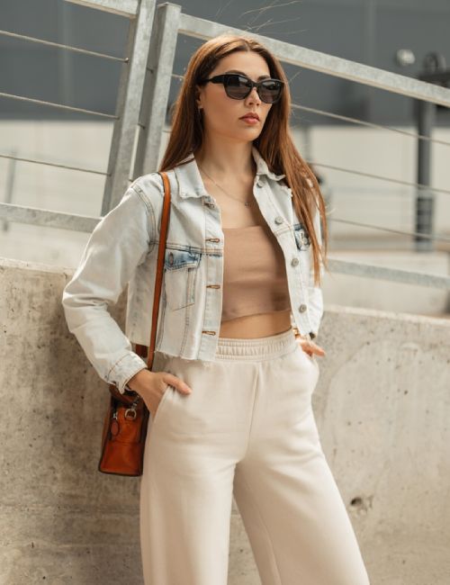 A model wearing a crop top with a cropped denim jacket