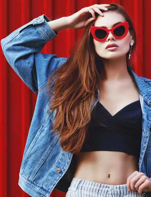 A woman wearing a denim jacket over a crop top