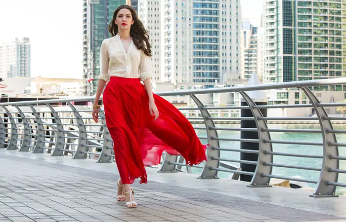 A woman dressed in a red maxi skirt paired with a white top