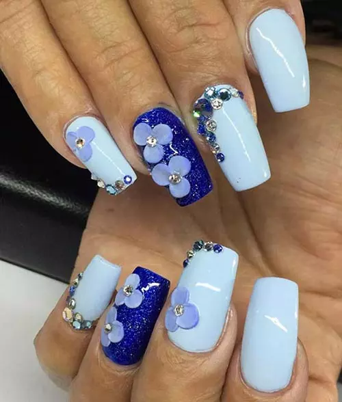 Shades of blue acrylic nail design with flower accents