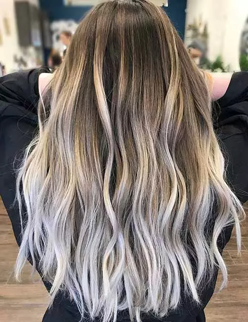 Balayage ash blonde highlights begin very close to the roots and end in an icy ash blonde at the tips