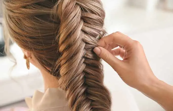 A woman setting her braids