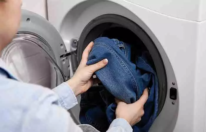 Woman putting her denim in the washing machine