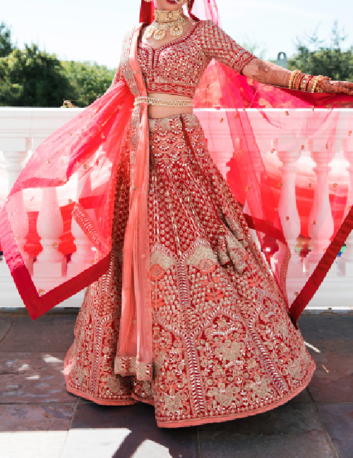 A bride with a double dupatta draping style using pink and red colors to create a contrast