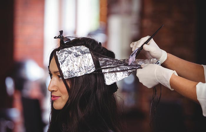A woman getting highlights done in a salon