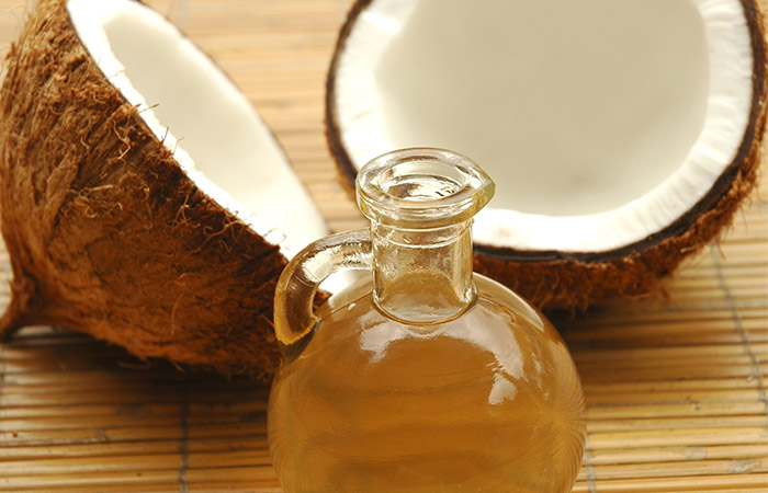 Jar of coconut oil with two pieces of coconut