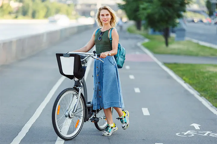 A woman wearing a long denim skirt with a crop top