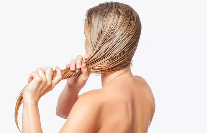 A woman applying hair mask to her hair