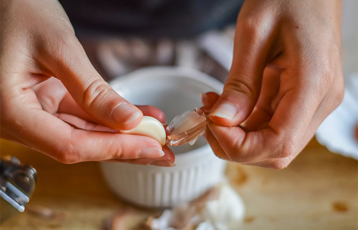Person preparing garlic remedy