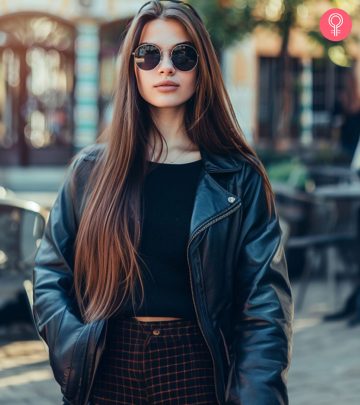 A woman is posing with her rose-brown hair