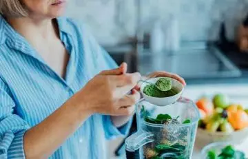 Woman making a green juice at home