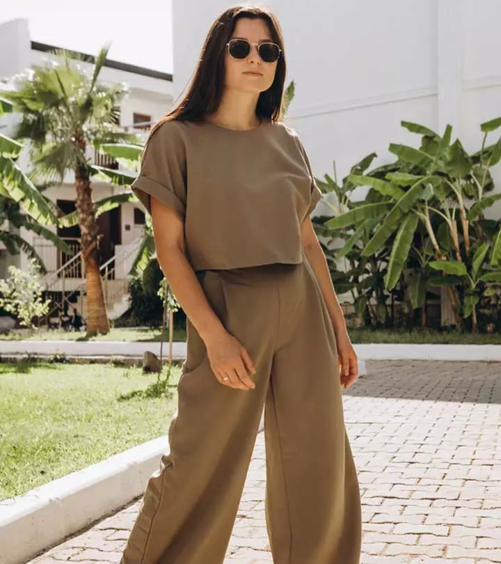 A woman wearing olive green pants and crop top