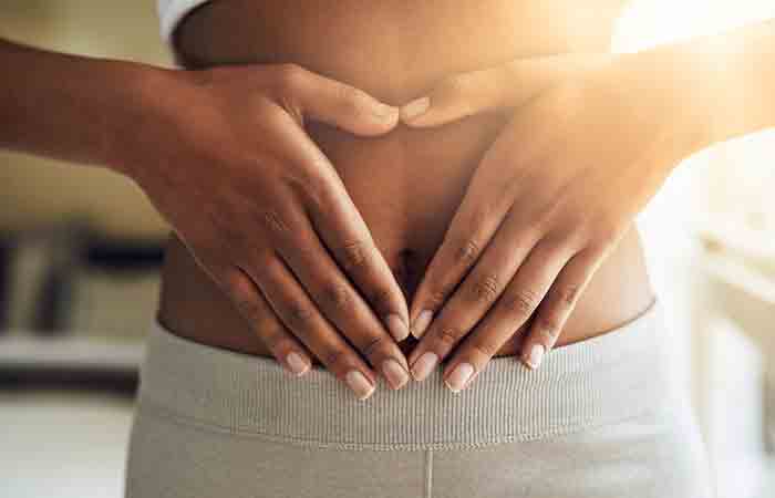 Woman with her hands on the stomach indicating good digestive health