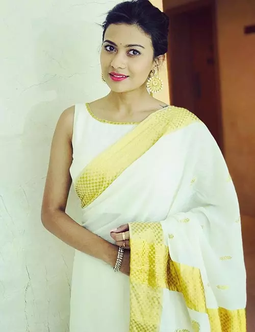 Pair Kasavu saree with off-white sleeveless blouse
