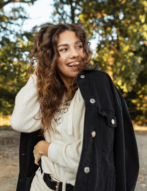 Portrait beautiful female in blue denim jacket in city. Fashionable young  woman with long dark hair looking at camera Stock Photo - Alamy