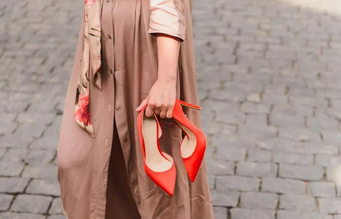 A woman holding heels
