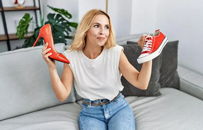 A woman choosing between heels and sneakers