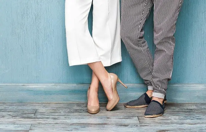 A woman in heels standing beside a man