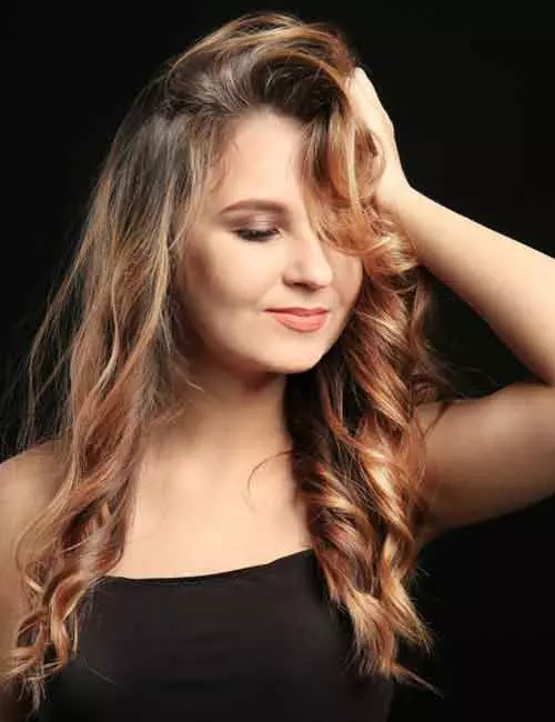 A woman with caramel highlights on dark hair