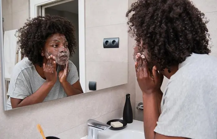 A woman applying African black soap on her face