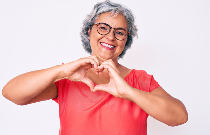 Woman makes a heart shape with hands to indicate a healthy heart