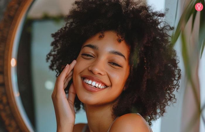 Woman touching her face and smiling at her reflection