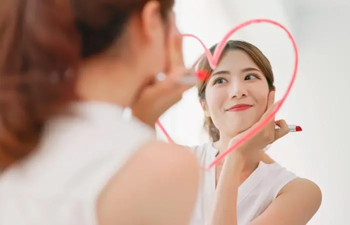 A woman in love drawing a heart on the mirror