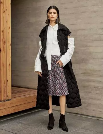 Model dressed in shirt and skirt overlaid by a convertible coat by ADEAM