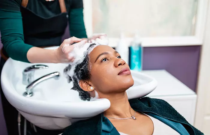 Stylist applying protein treatment to client's natural hair