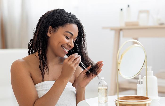 Woman applying protein treatment oil for natural hair