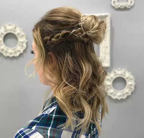 Blonde curly hair in braided half top knot