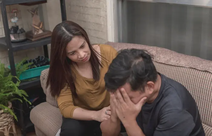 A man crying while covering his face