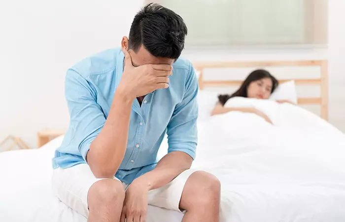 Wife tries to console disturbed husband in the bedroom