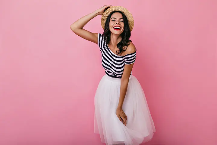 A woman in a white skirt and striped top