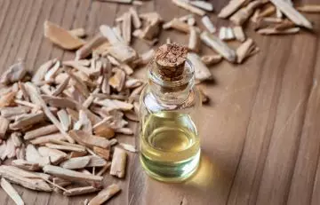 Bottle of cedarwood essential oil with wood chips