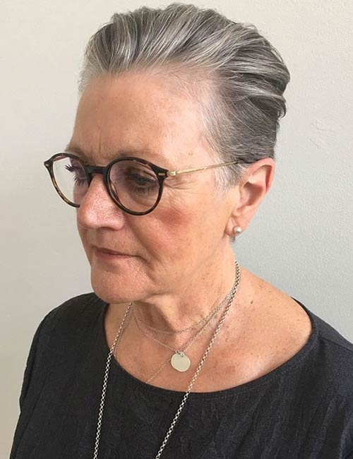 Slicked back pixie hairstyle for older women with glasses