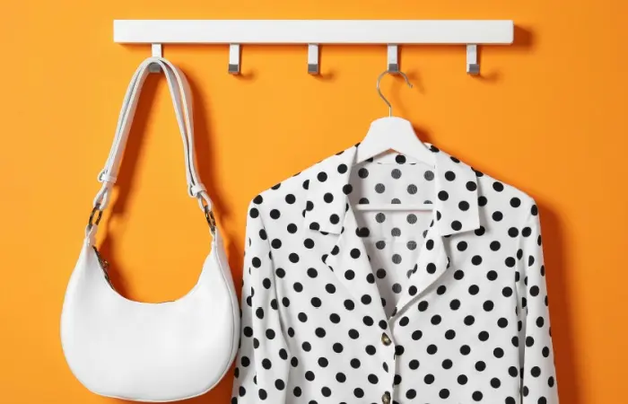 A white shirt with black polka dots on the hanger.