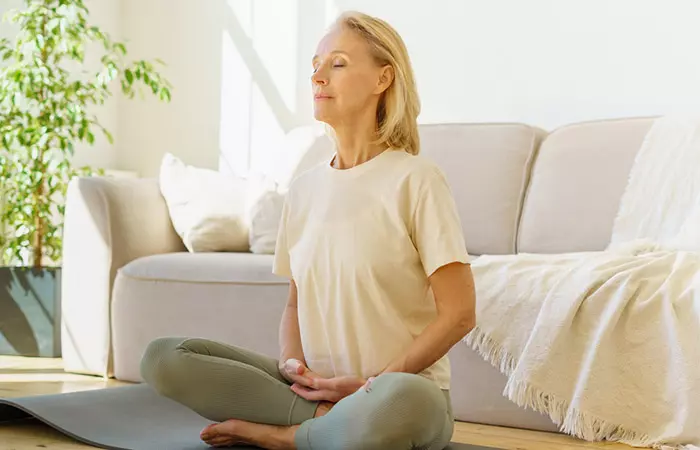 Woman sitting upright on a mat to make herself burp