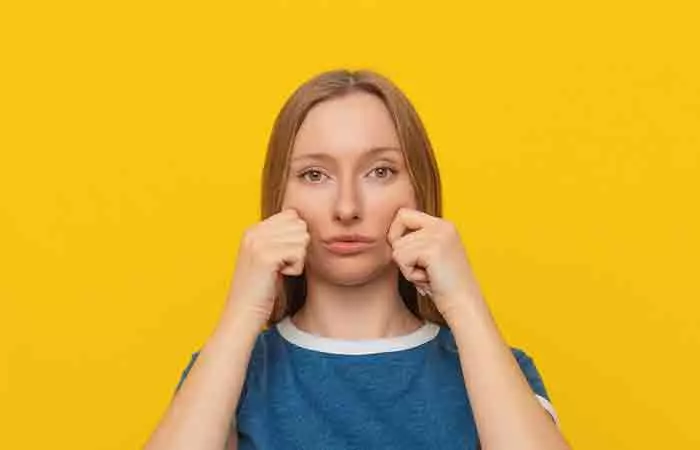 Woman holding her cheek skin